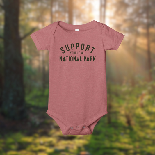 Support Your Local National Park baby onesie in forest setting, made of soft 100% cotton for little explorers.