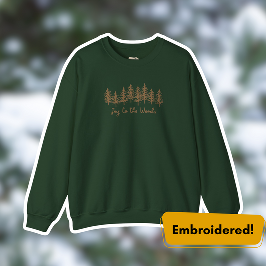 Joy to the Woods embroidered crewneck in forest green with pine tree design, perfect for cozy holiday wear.