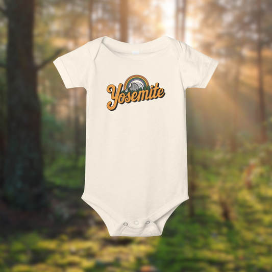 Yosemite rainbow baby onesie in a forest setting, featuring soft cotton fabric and cheerful design.