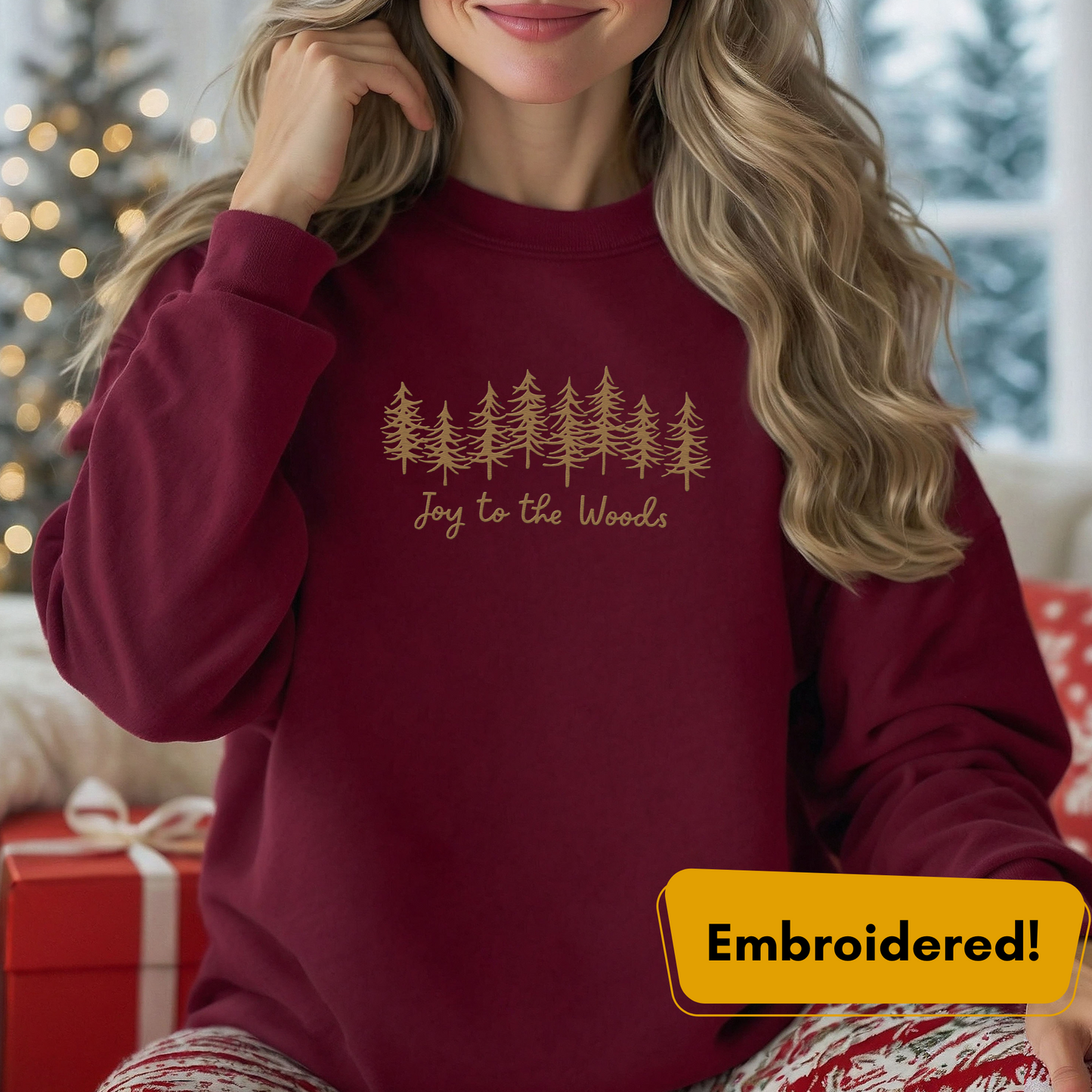 Joy to the Woods embroidered crewneck in maroon with gold pine tree design for cozy holiday style.