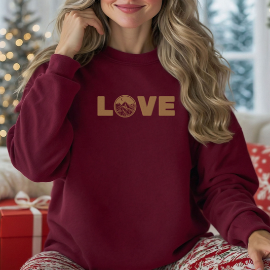 Cozy maroon embroidered sweatshirt featuring 'LOVE' and a mountain scene, perfect for nature lovers.