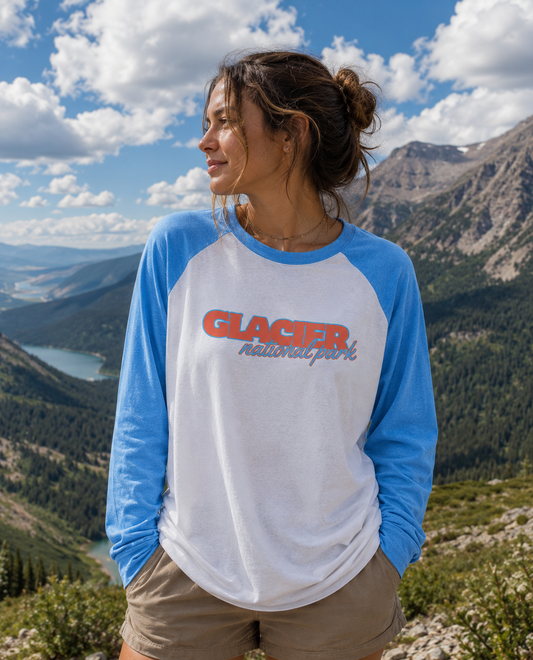 Woman wearing Glacier Heritage raglan tee in Glacier National Park with mountain view in the background.