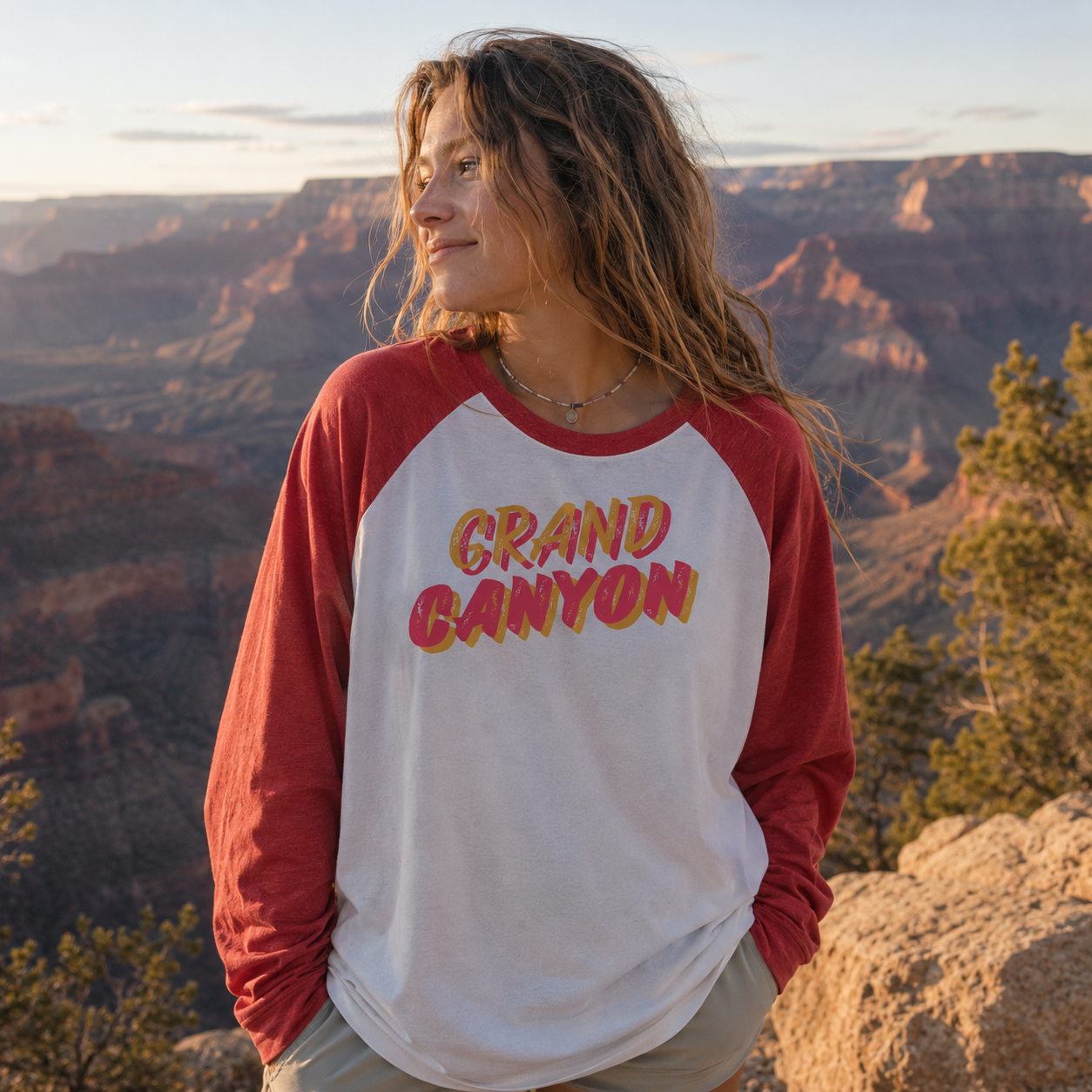 Woman wearing Grand Canyon heritage tee with canyon views in the background during sunset.
