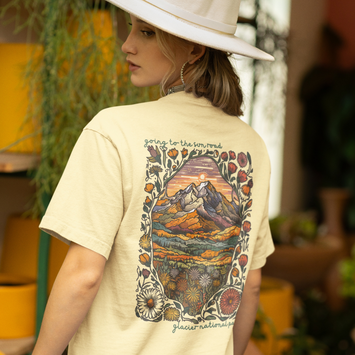 Going to the Sun Road T-shirt featuring vibrant Glacier National Park mountain scene and floral design on back.