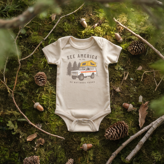 See America Scout Baby Onesie on moss, featuring a vintage camper design perfect for adventures.