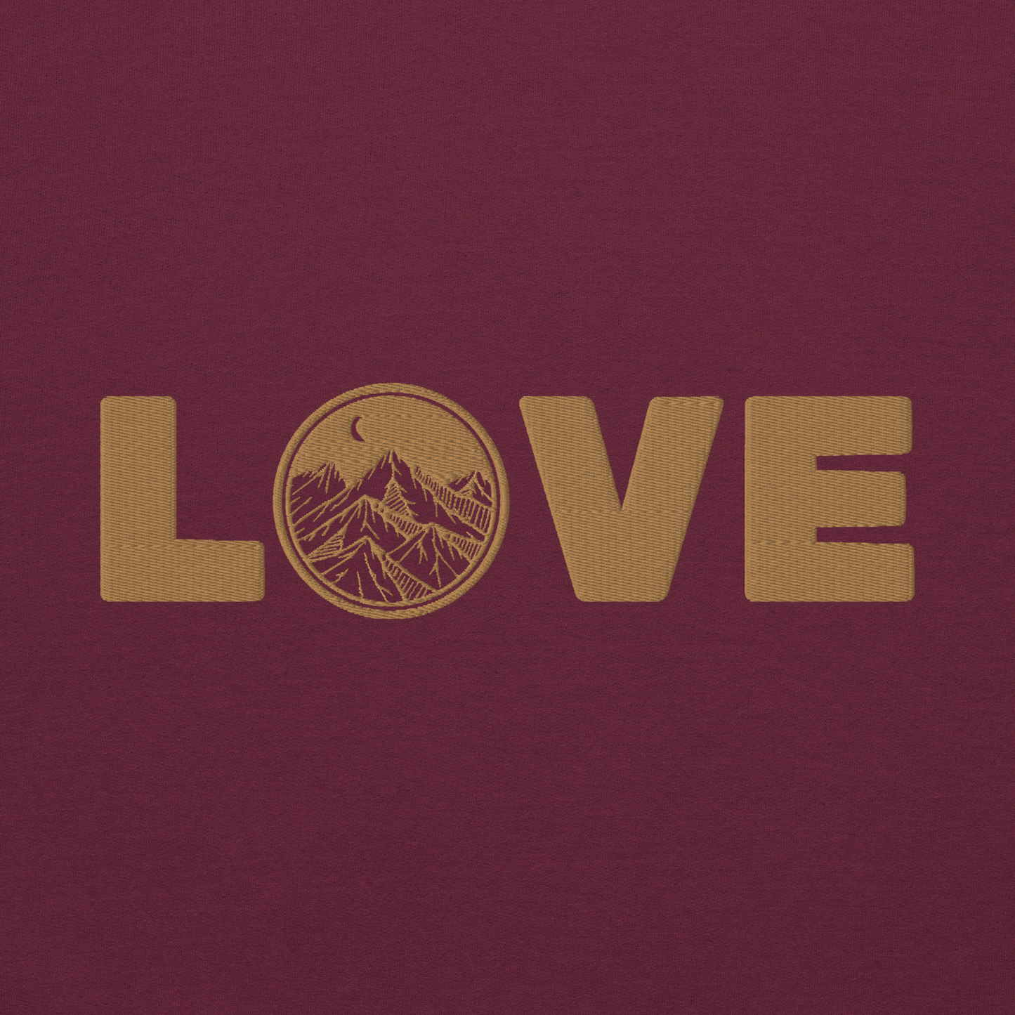 Embroidered sweatshirt design with the word 'LOVE' in gold thread and a mountain scene in the 'O' on a burgundy background.