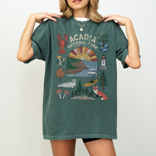 Woman wearing Acadia National Park Tee featuring wildlife and landmarks like lobsters, seals, and lighthouses.