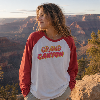 Woman wearing Grand Canyon heritage tee with canyon views in the background during sunset.