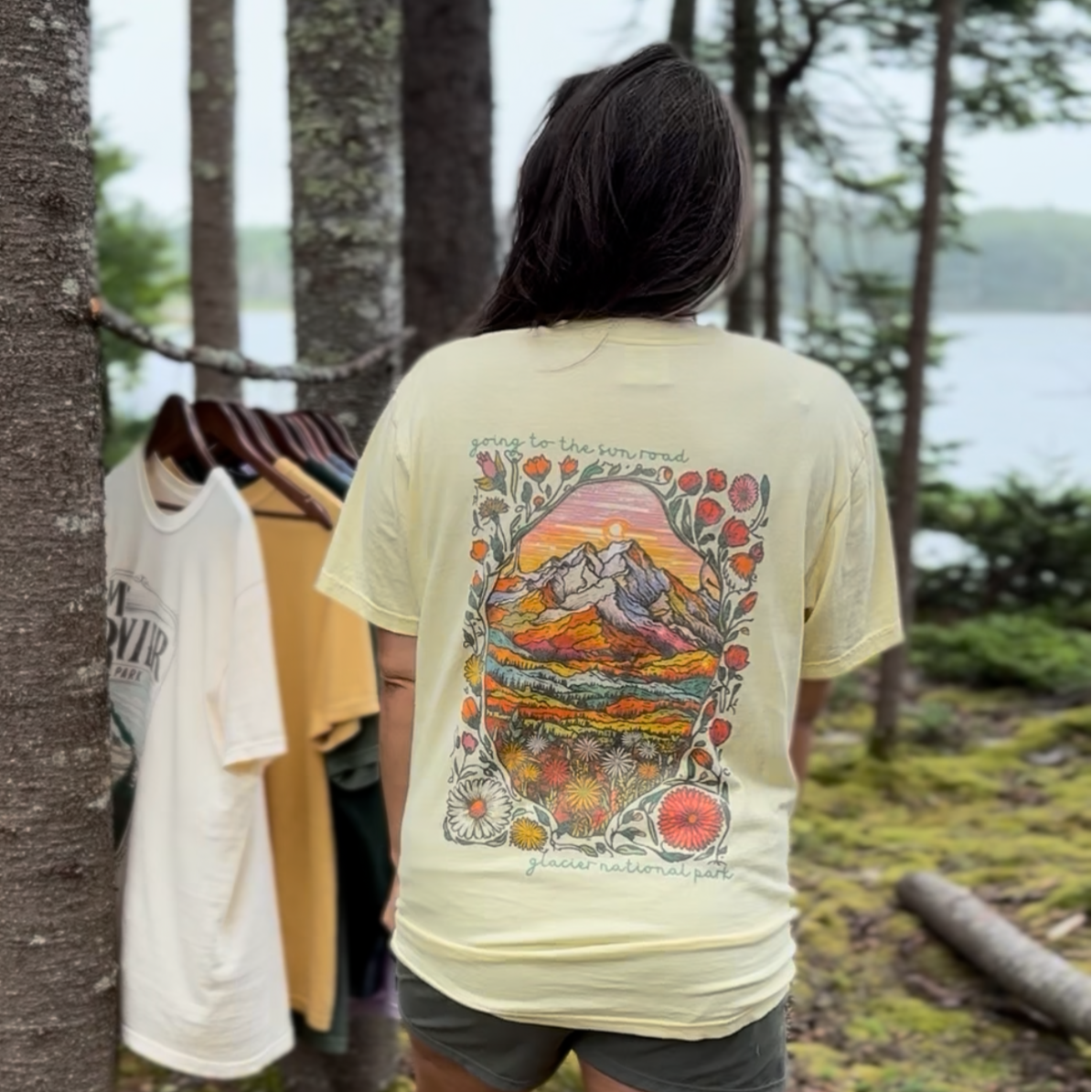 Person wearing a t-shirt with a colorful design in a forest setting
