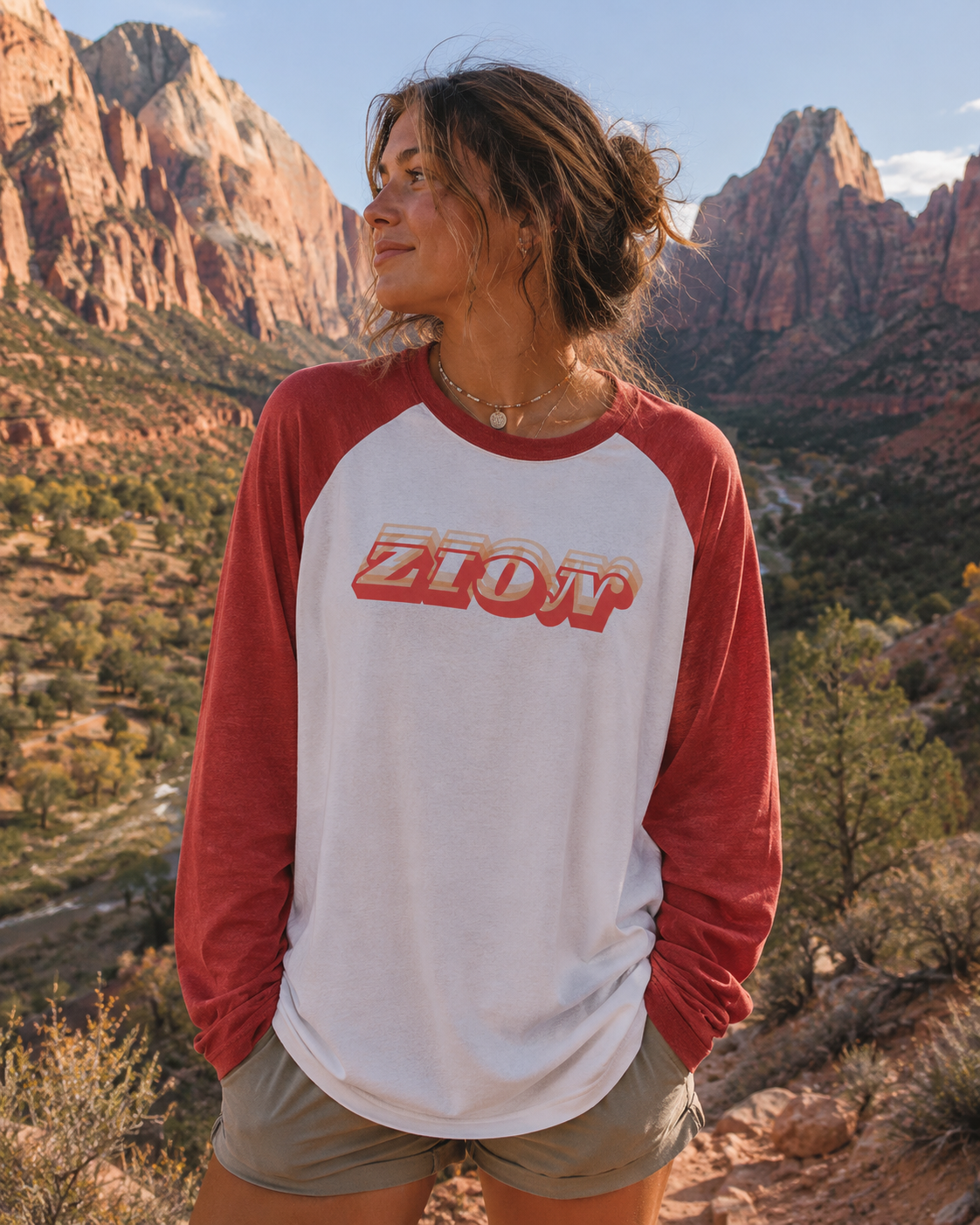 Person wearing Zion Heritage Raglan Tee in desert landscape with red rock canyons.