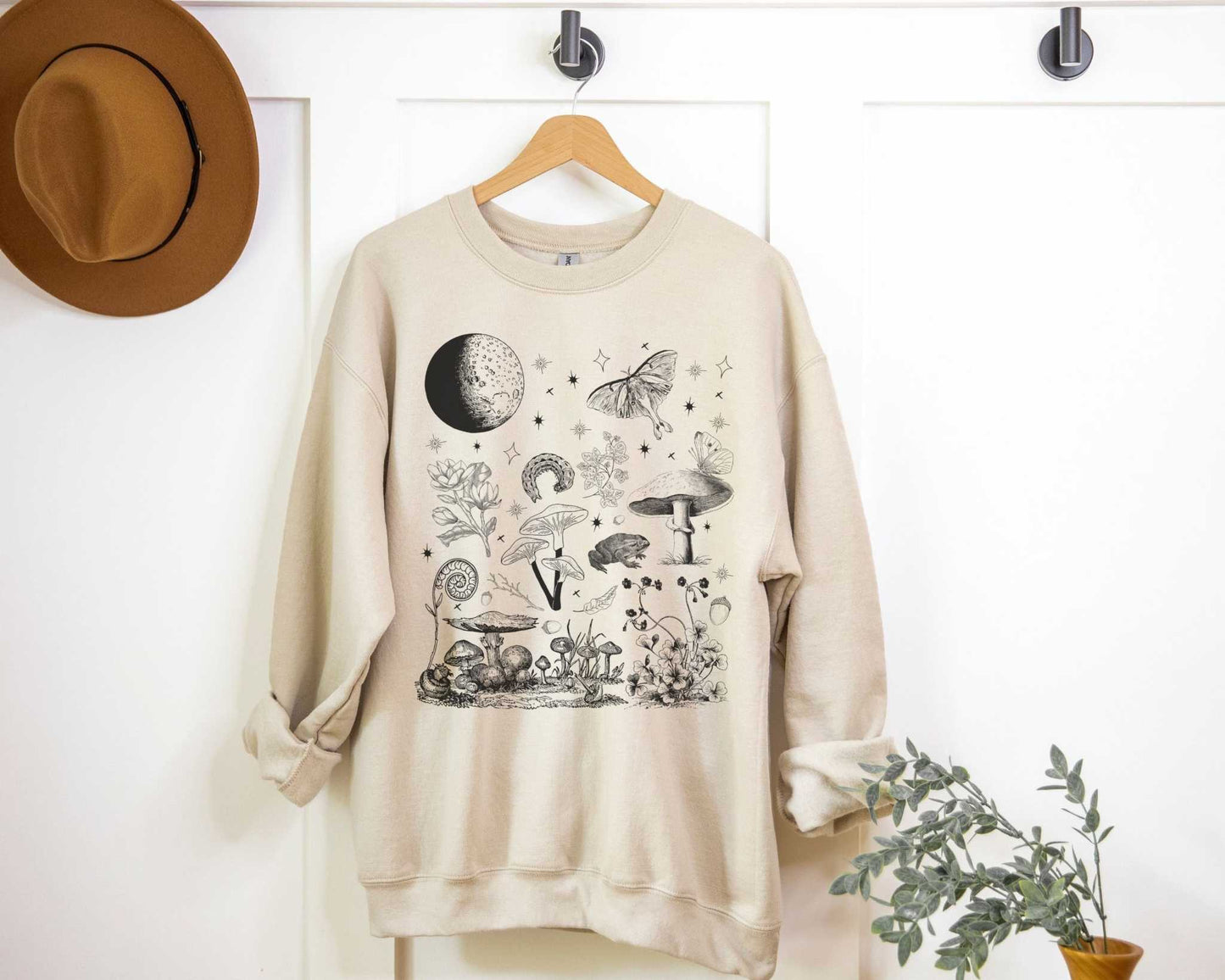 Mushroom Forest SweatshirtBring the beauty and magic of the forest at night into your fall and winter outfit rotation with this mushroom forest sweatshirt. Whether you're going for a forestco